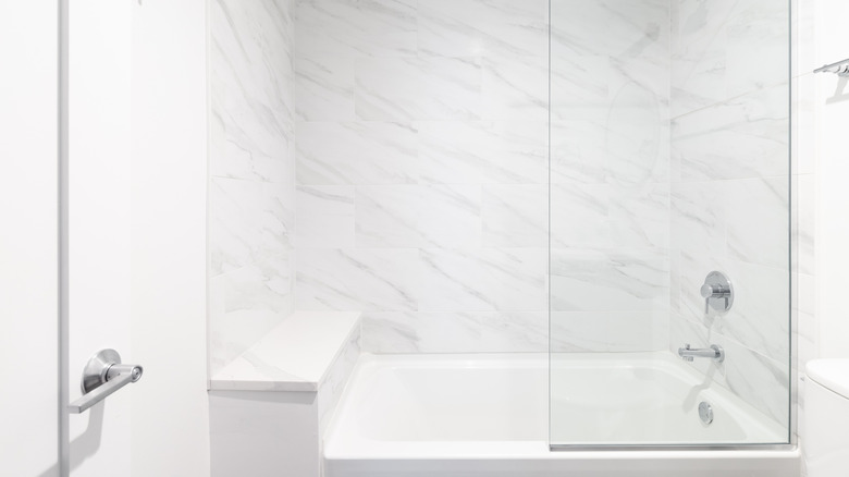 Built-in shower bench in white tub and shower combination