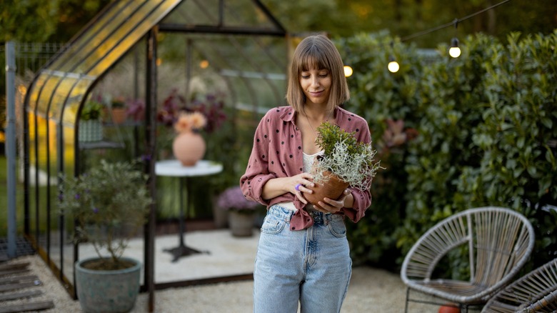 Woman holding potted plant outdoors