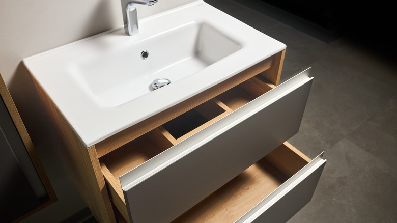 Bathroom sink cabinet open drawers