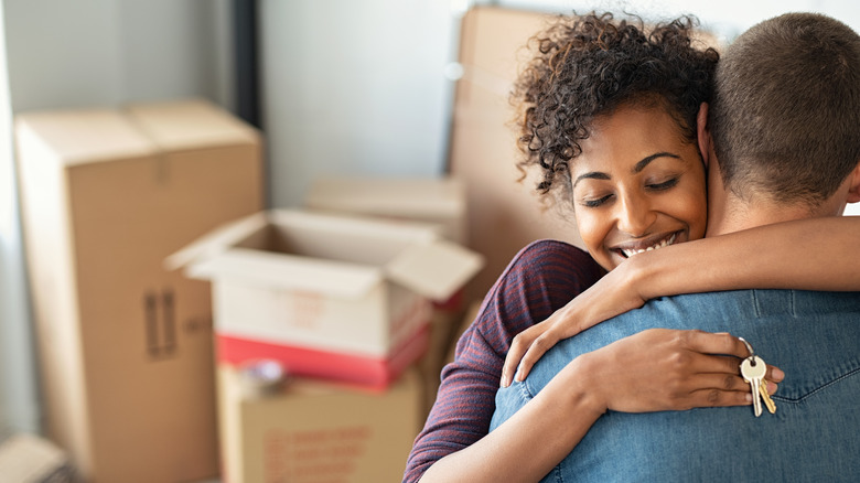 Couple hugging with boxes