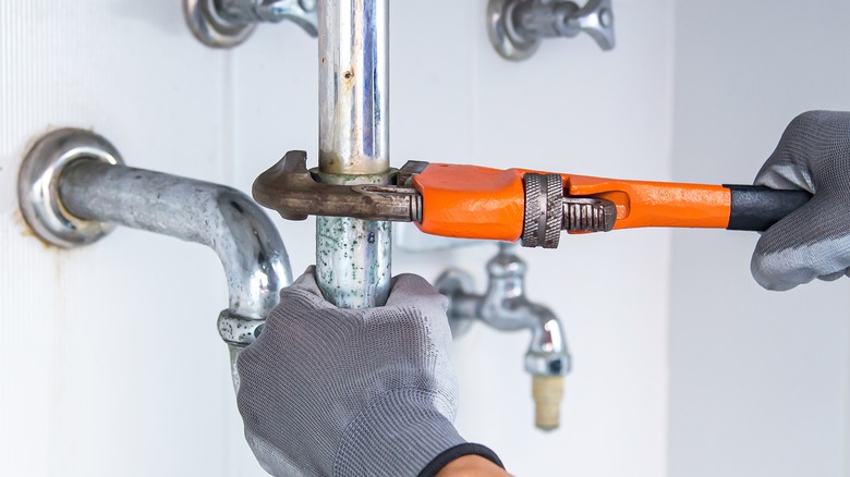 hands fixing a pipe