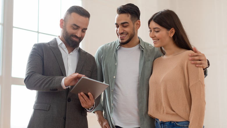 Couple standing with real estate agent 