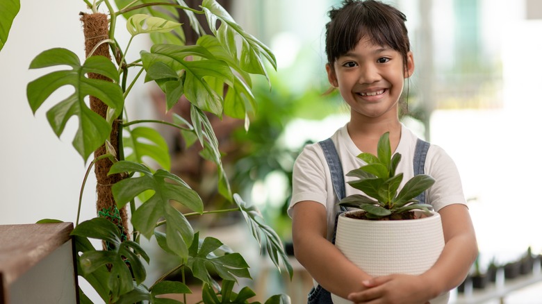 kid holding plant pot