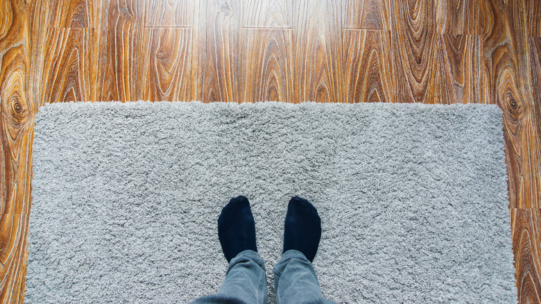 Person standing on area rug that covers laminate floor