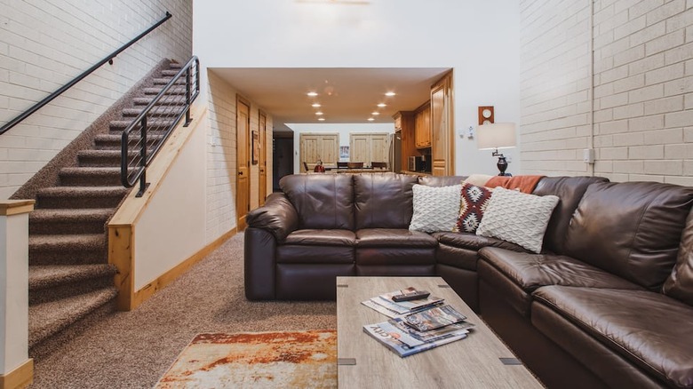 dark leather couch with white walls 