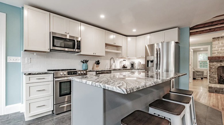 white kitchen with unique marble island