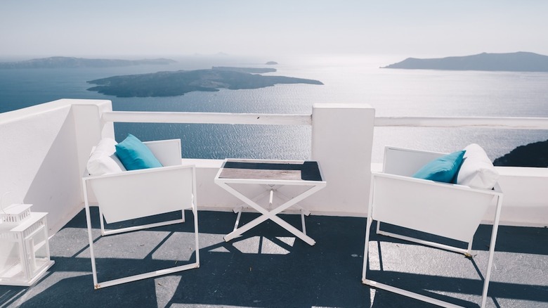 white patio chairs overlooking ocean