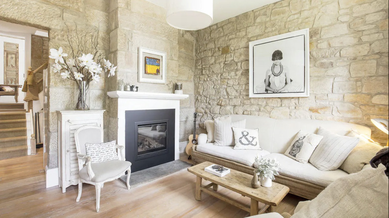 Stone-walled living room with white and tan furnishings