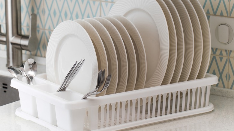 Dishes in traditional white drying rack on countertop