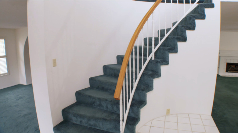 Entryway with bright green carpet on stairs