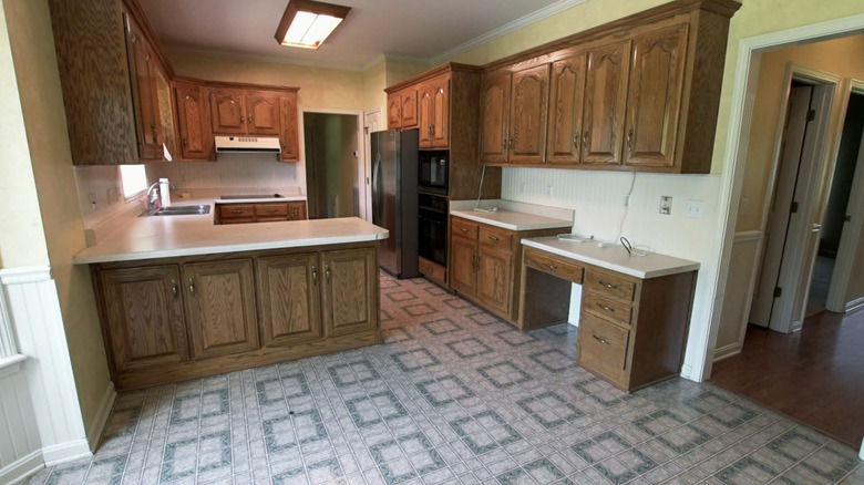 outdated kitchen with wooden cabinets and linoleum floors