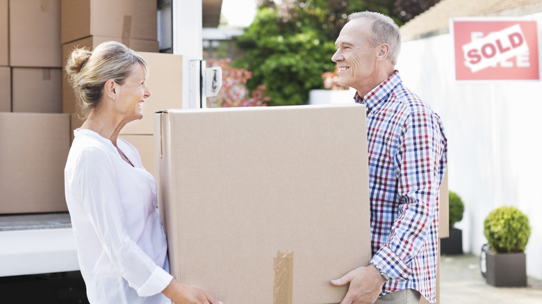 middle aged couple moving box