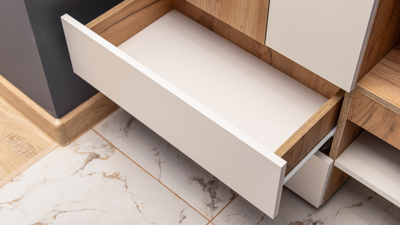 A kitchen is fitted with white drawers