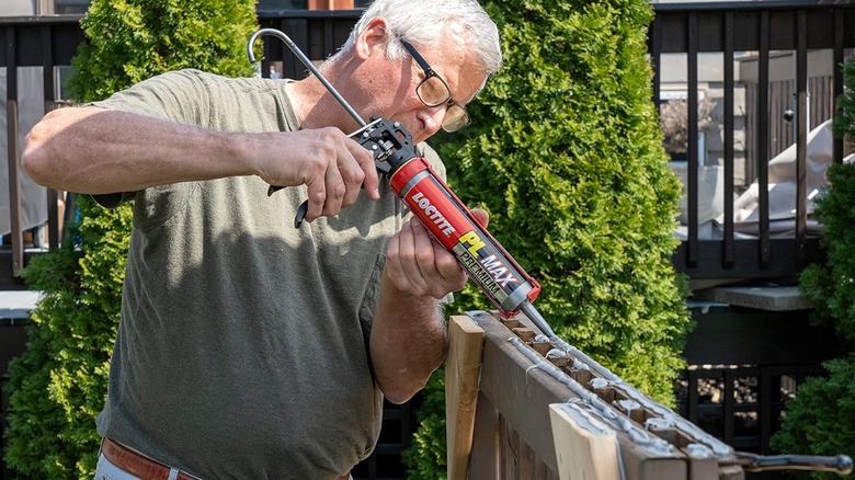 A man applying Loctite adhesive to wood