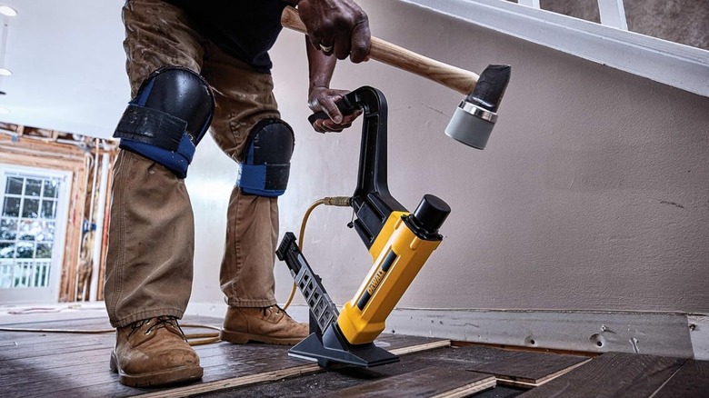 A person adding staples to a DeWalt 2in1 flooring tool