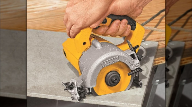 A person using a DeWalt wet/dry tile cutter