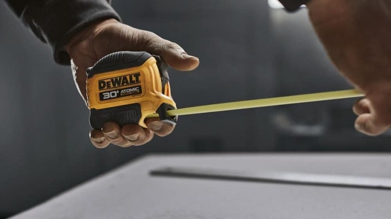 A person using a DeWalt tape measure