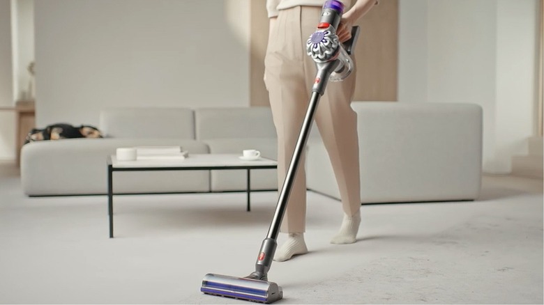 woman using Dyson cordless vacuum