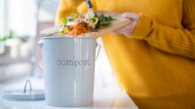 woman adding compost to bin