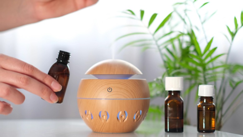 Person adding oil to diffuser