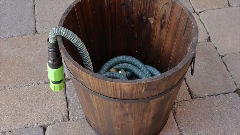 green hose in wooden bucket