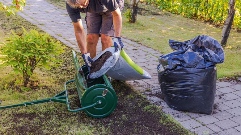 gardener filling topdresser with compost