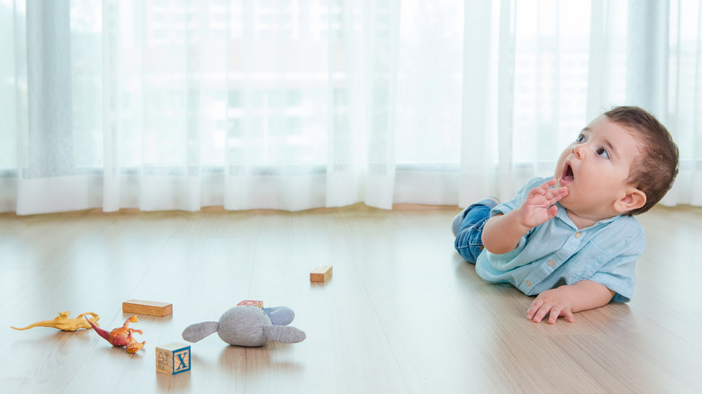 baby boy crawling on hardwood floor