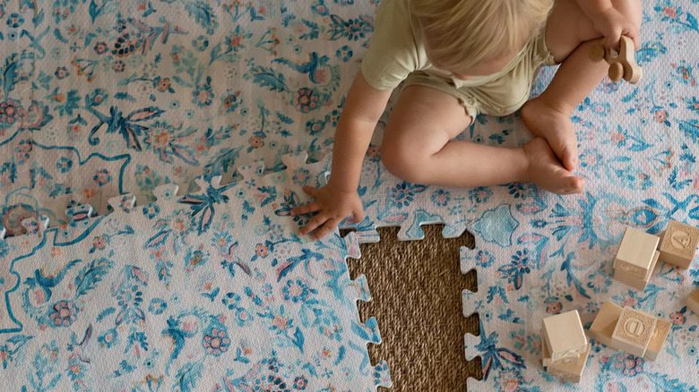 child playing on multicolored rubber tile