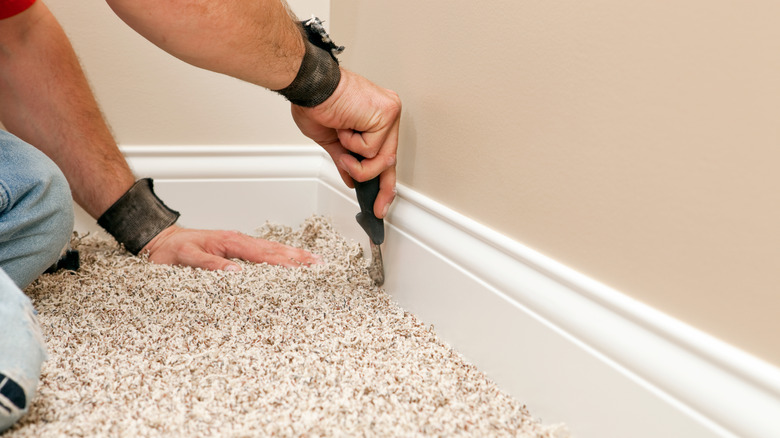 Man installing carpet inside room