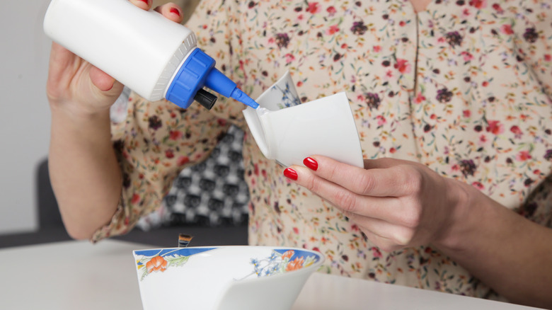 woman gluing broken bowl pieces