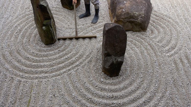 Raking a Zen garden using a traditional wooden rake