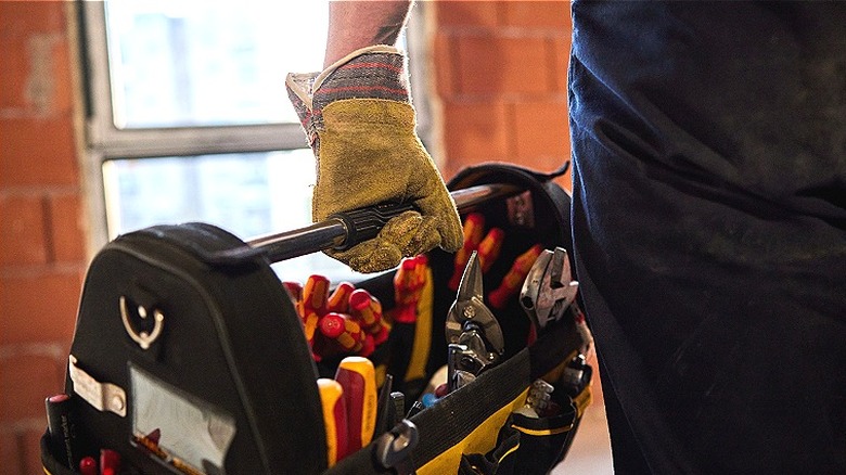 Person holding toolbox of tools