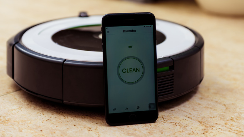 Smart phone leaning against Roomba