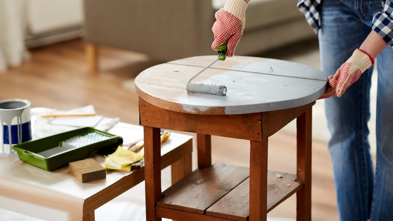 person painting circular wood table