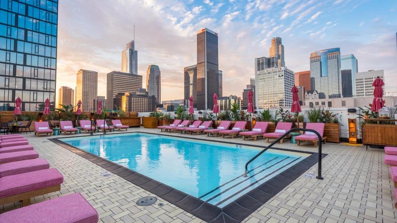 rooftop pool with pink lounge chairs 