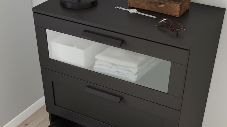 A black BRIMNES three drawer chest with a glass panel drawer