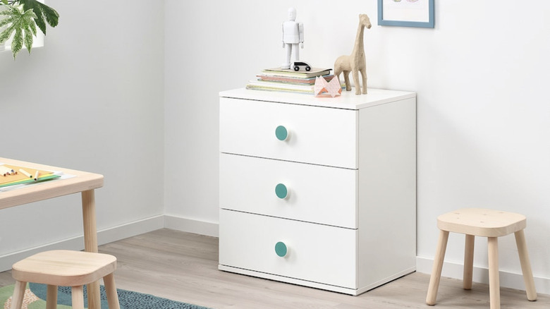 The white GODISHUS drawer with green knobs in child's room