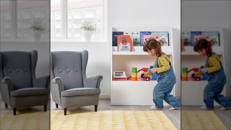 A child puts away toys on an IKEA BERGIG bookcase