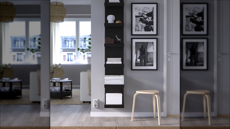 A minimalist IKEA wall shelf holds books and magazines