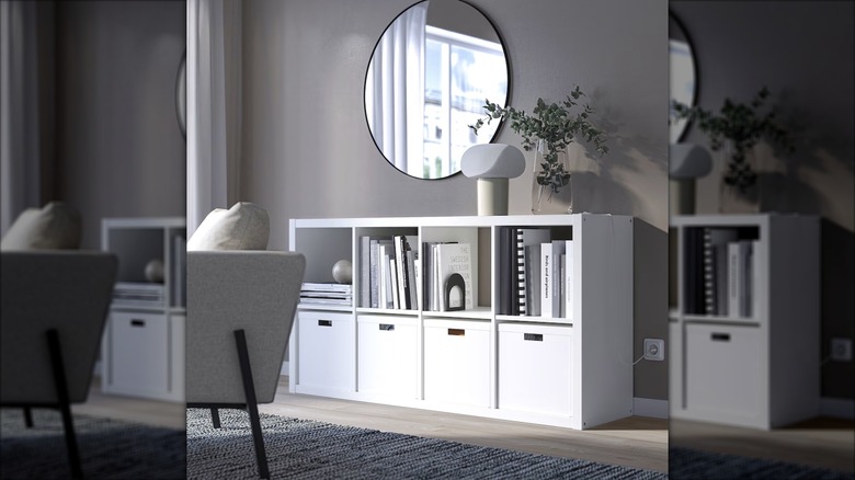 A Kallax bookcase from IKEA displays books below a round mirror