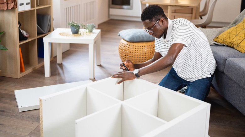 Person putting together an IKEA cube shelving unit