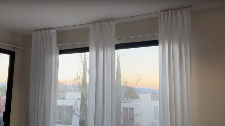 sheer curtains hanging on track above window