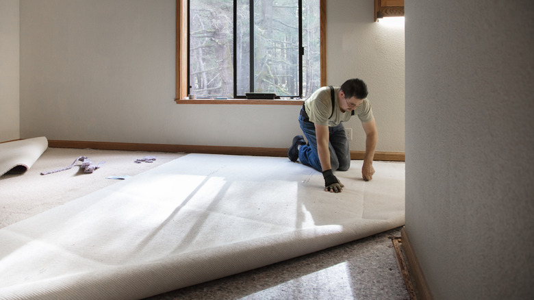 man installing carpeting