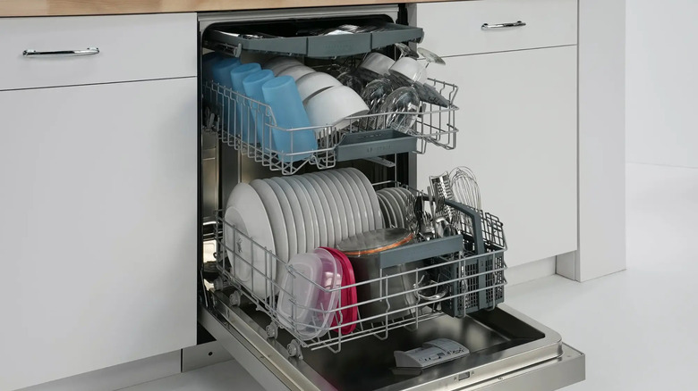 open narrow Bosch dishwasher with clean dishes