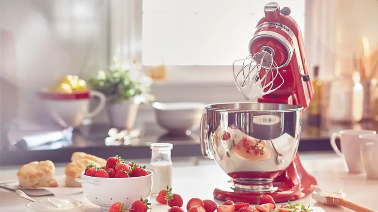 Red KitchenAid mixer with stainless steel bowl making  strawberry dessert