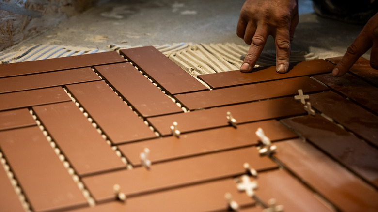 Person installing herringbone brick flooring