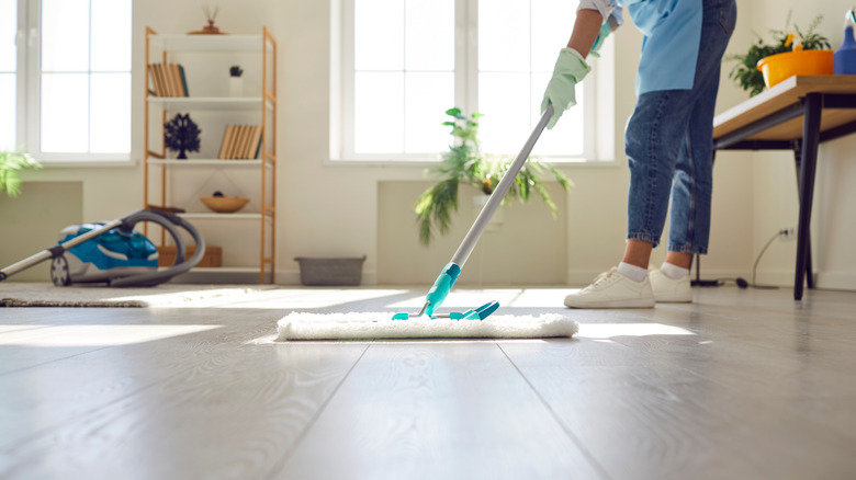 Someone using a mop to clean wood floors