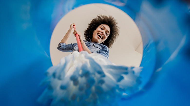 Woman dipping mop into bucket