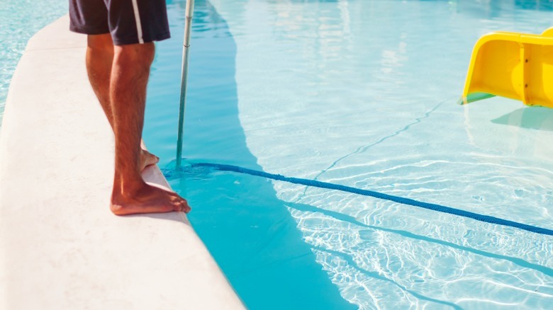 Man vacuuming pool