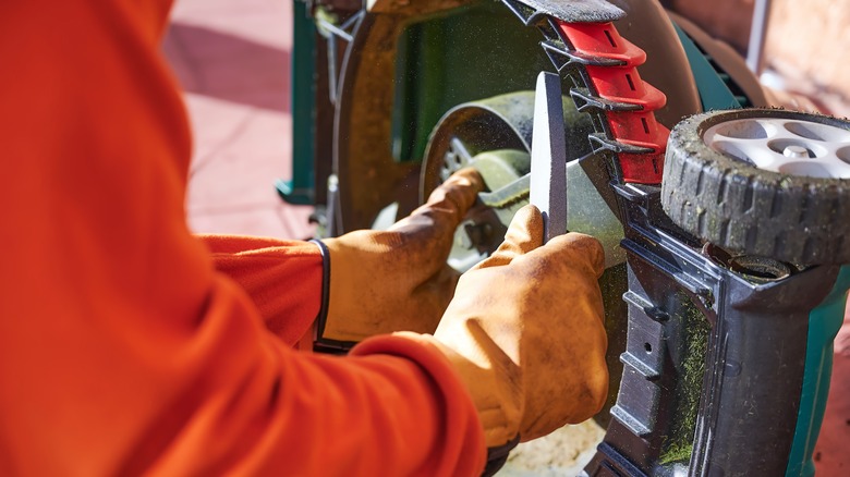 gloved hands sharpen blades